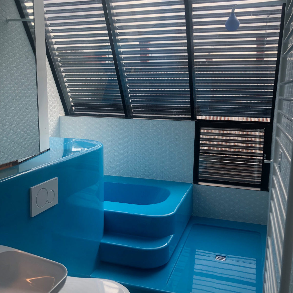 Union St House Bright blue floor and bathtub in bathroom with white tiles and louvered windows